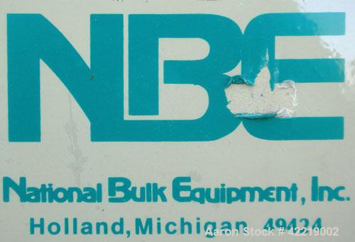 Used NBE Dry Bulk Storage Hopper, approximately 40 cubic feet, carbon steel. 44" wide x 44" long x 18" deep x coned bottom. Approximate 1400 pound capacity. Includes a top extension and grate. Mounte...