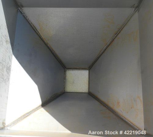 Used NBE Dry Bulk Storage Hopper, approximately 50 cubic feet, carbon steel. 48" wide x 48" long x coned bottom. Approximate 1750 pound capacity. Mounted in a carbon steel frame with forklift access.