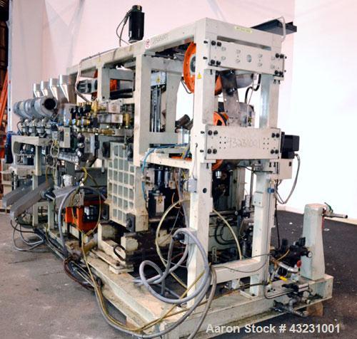 Used Uniloy Milacron Alkam Stretch Blow Molding Machine, Model BM-4. (4) Blow cavities/mould, 130mm distance between cavities. Unit includes an infeed system with a hopper, elevator, orienter, and in...