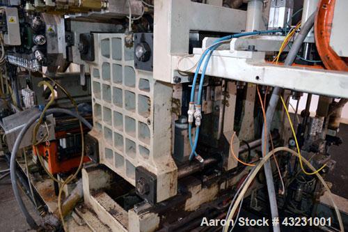Used Uniloy Milacron Alkam Stretch Blow Molding Machine, Model BM-4. (4) Blow cavities/mould, 130mm distance between cavities. Unit includes an infeed system with a hopper, elevator, orienter, and in...