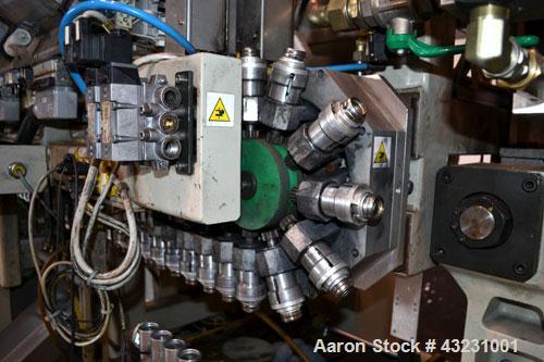Used Uniloy Milacron Alkam Stretch Blow Molding Machine, Model BM-4. (4) Blow cavities/mould, 130mm distance between cavities. Unit includes an infeed system with a hopper, elevator, orienter, and in...