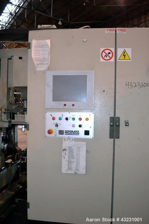Used Uniloy Milacron Alkam Stretch Blow Molding Machine, Model BM-4. (4) Blow cavities/mould, 130mm distance between cavities. Unit includes an infeed system with a hopper, elevator, orienter, and in...
