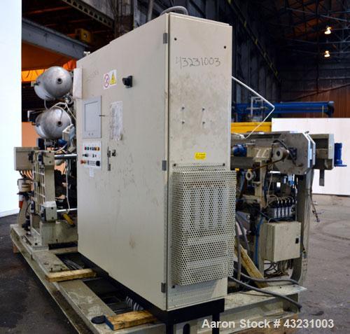 Used Uniloy Milacron Alkam Stretch Blow Molding Machine, Model BM-5. (5) Blow cavities/mould, 105mm distance between cavities. Unit includes an infeed system with a hopper, elevator, orienter, and in...