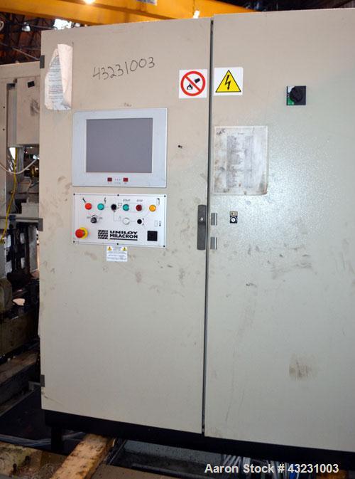 Used Uniloy Milacron Alkam Stretch Blow Molding Machine, Model BM-5. (5) Blow cavities/mould, 105mm distance between cavities. Unit includes an infeed system with a hopper, elevator, orienter, and in...