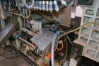Used Uniloy Milacron Alkam Stretch Blow Molding Machine, Model BM-4. (4) Blow cavities/mould, 130mm distance between cavities. Unit includes an infeed system with a hopper, elevator, orienter, and in...