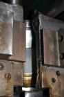 Used Uniloy Milacron Alkam Stretch Blow Molding Machine, Model BM-5. (5) Blow cavities/mould, 105mm distance between cavities. Unit includes an infeed system with a hopper, elevator, orienter, and in...