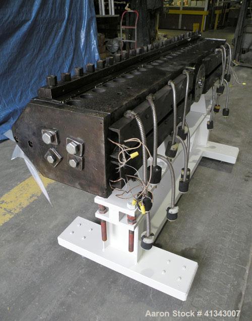 Used Titan Sheet Die, 78" wide. Approximate 1-5/8" diameter back center feed. Mounted on a cart with casters.