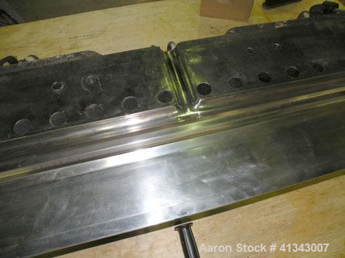 Used Titan Sheet Die, 78" wide. Approximate 1-5/8" diameter back center feed. Mounted on a cart with casters.