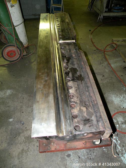 Used Titan Sheet Die, 78" wide. Approximate 1-5/8" diameter back center feed. Mounted on a cart with casters.