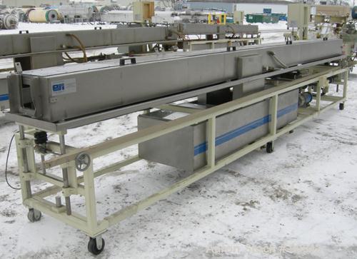 Used: Extrusion Services Inc.(ESI) spray cooling tank, 304 stainless steel. 16" wide x 11" deep x 20' long.(4) section top cover. Includes holding tank,pump, heat exchanger,and control panel. Mounted...