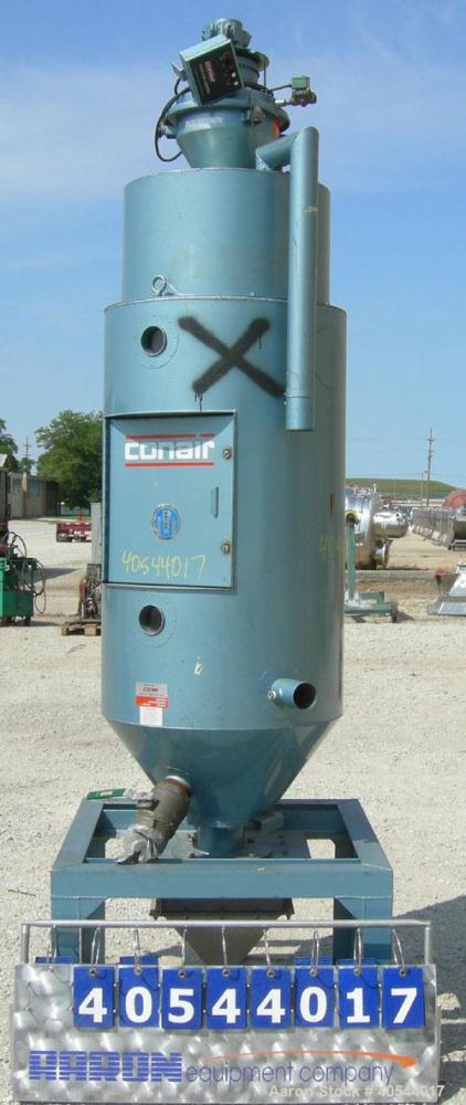 Used Conair insulated drying hopper, carbon steel, model 1805390300. 26" diameter x 46" straight side. Top mounted loader, side access door. Mounted on a frame.