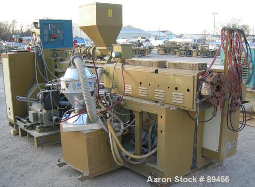 USED: Amut twin screw extruder, 92 mm screw diameter, model BA92. Approximate 22:1 L/D ratio. Counter-rotating screw design. 5 zone top vented, electrically heated, air cooled barrel with vacuum pump...