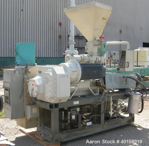 Used Cincinnati Milicron Conical Counter-Rotating Twin Screw Extruder, 55 mm, model E55 Pinnacle. Electrically heated, water cooled 4 zone vented barrel with pump. Water cooled feed throat with a dos...