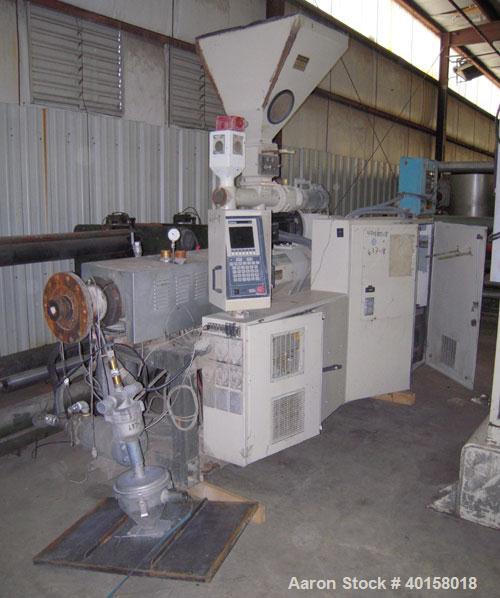 Used Cincinnati Milicron Conical Counter-Rotating Twin Screw Extruder, 55 mm, model E55 Pinnacle. Electrically heated, water cooled vented barrel with pump. Water cooled feed throat with a dosing fee...