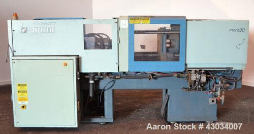Used Sandretto Micro30 30 Ton Hydraulic Horizontal Injection Mold Machine, Model 300/107. Approximate 1-3/4" diameter tie bars, 12" x 12" distance between bars, 17-3/4" x 17-3/4" platen size. Operato...