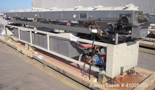 Used Conair Vacuum Sizing Tank, Model MT104-22-5, 304 Stainless Steel. 12" wide x 265" long x 7" deep. Includes a holding tank and pumps. Mounted on a carbon steel frame on casters.