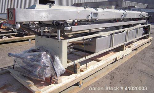 Used Conair Vacuum Sizing Tank, Model MT104-22-5, 304 Stainless Steel. 12" wide x 265" long x 7" deep. Includes a holding tank and pumps. Mounted on a carbon steel frame on casters.