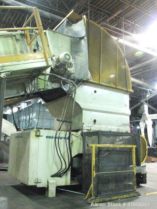 Used Uni-Shred Single Rotor Shredder, carbon steel. 63" x 67" feed. Hydraulic ram feeder. Shreddder driven by a 150 hp motor. Includes belt discharge conveyor.