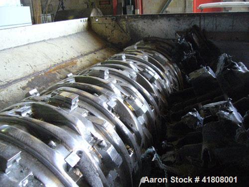 Used Uni-Shred Single Rotor Shredder, carbon steel. 63" x 67" feed. Hydraulic ram feeder. Shreddder driven by a 150 hp motor. Includes belt discharge conveyor.