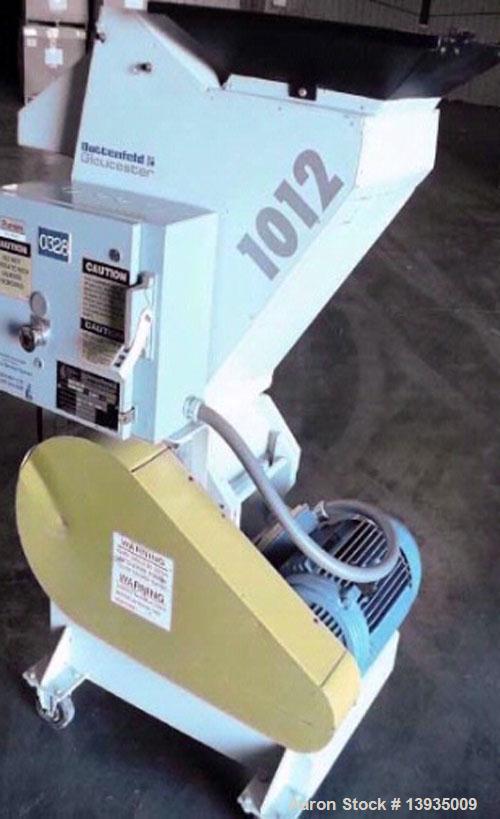 Used Battenfeld Gloucester 1012-BP-10. 10" x 12" throat size opening, 10 hp, 2 rotor knives, 1 bed knife, 230V, includes conveyor.