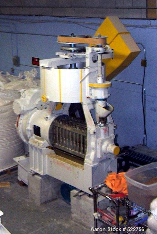 USED: Screw type oil expeller. Capacity: five tons of crushing per shift of eight hours. 25 hp motor with 8" to 24" pulley for drive. Stainless steel body cover with the tank.