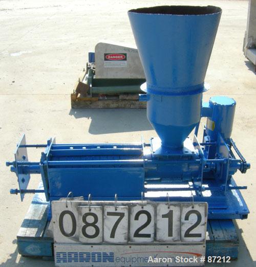 USED: Screw press, carbon steel. Approximate 6" diameter x 21" long chamber. 4" top feed with hopper. Screw driven by a 3/4 HP, 3/60/209-230/460 volt, 1725 RPM gear motor. Base mounted.
