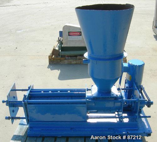 USED: Screw press, carbon steel. Approximate 6" diameter x 21" long chamber. 4" top feed with hopper. Screw driven by a 3/4 HP, 3/60/209-230/460 volt, 1725 RPM gear motor. Base mounted.