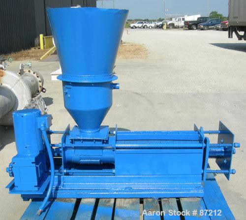 USED: Screw press, carbon steel. Approximate 6" diameter x 21" long chamber. 4" top feed with hopper. Screw driven by a 3/4 HP, 3/60/209-230/460 volt, 1725 RPM gear motor. Base mounted.