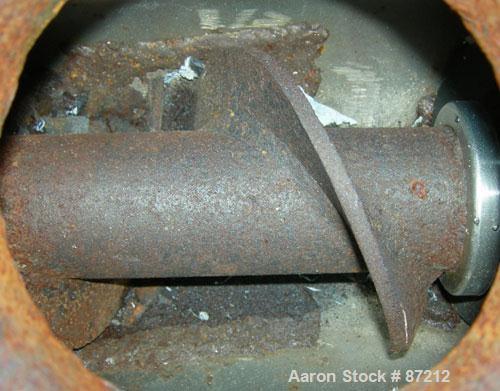 USED: Screw press, carbon steel. Approximate 6" diameter x 21" long chamber. 4" top feed with hopper. Screw driven by a 3/4 HP, 3/60/209-230/460 volt, 1725 RPM gear motor. Base mounted.