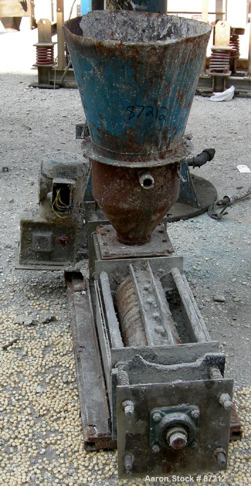 USED: Screw press, carbon steel. Approximate 6" diameter x 21" long chamber. 4" top feed with hopper. Screw driven by a 3/4 HP, 3/60/209-230/460 volt, 1725 RPM gear motor. Base mounted.