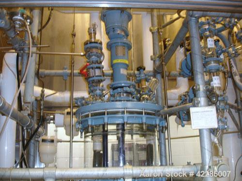Used Buchi Reactor Train consisting of: (1) Buchi 100 Liter Glass Reactor, (1) Buchi 100 Liter Glass Agitated Receiver, (2) Vertical Glass Coil Condensers, (1) Vertical Coil Vent Condenser. 