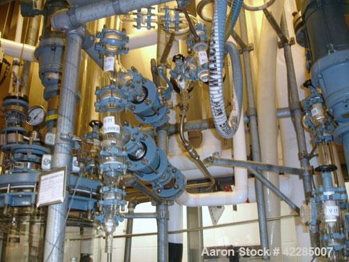 Used Buchi Reactor Train consisting of: (1) Buchi 100 Liter Glass Reactor, (1) Buchi 100 Liter Glass Agitated Receiver, (2) Vertical Glass Coil Condensers, (1) Vertical Coil Vent Condenser. 