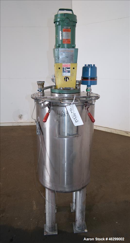 Used Tank, Approximately 40 Gallons, 304 Stainless Steel, Vertical. 20" Diameter x 30" straight side. Bolt-on flat top with 1/4 hinged cover, dished bottom. Top entering Lightnin agitator model XJC-3...