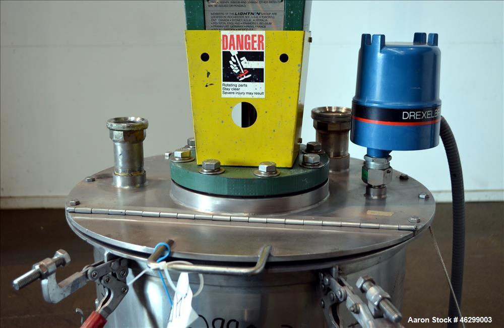 Used Tank, Approximately 40 Gallons, 304 Stainless Steel, Vertical. 20" Diameter x 30" straight side. Bolt-on flat top with 1/4 hinged cover, dished bottom. Top entering Lightnin agitator model XJC-3...