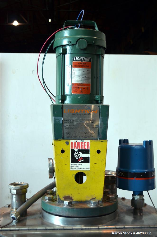 Used Tank, Approximately 40 Gallons, 304 Stainless Steel, Vertical. 20" Diameter x 30" straight side. Bolt-on flat top with 1/4 hinged cover, dished bottom. Top entering Lightnin agitator model XJC-3...