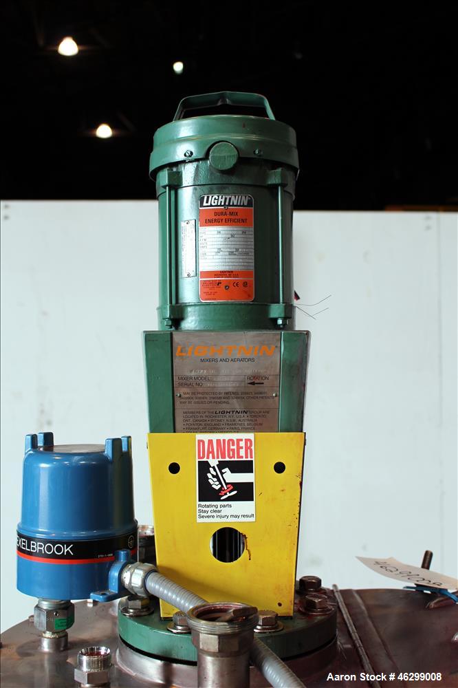 Used Tank, Approximately 40 Gallons, 304 Stainless Steel, Vertical. 20" Diameter x 30" straight side. Bolt-on flat top with 1/4 hinged cover, dished bottom. Top entering Lightnin agitator model XJC-3...