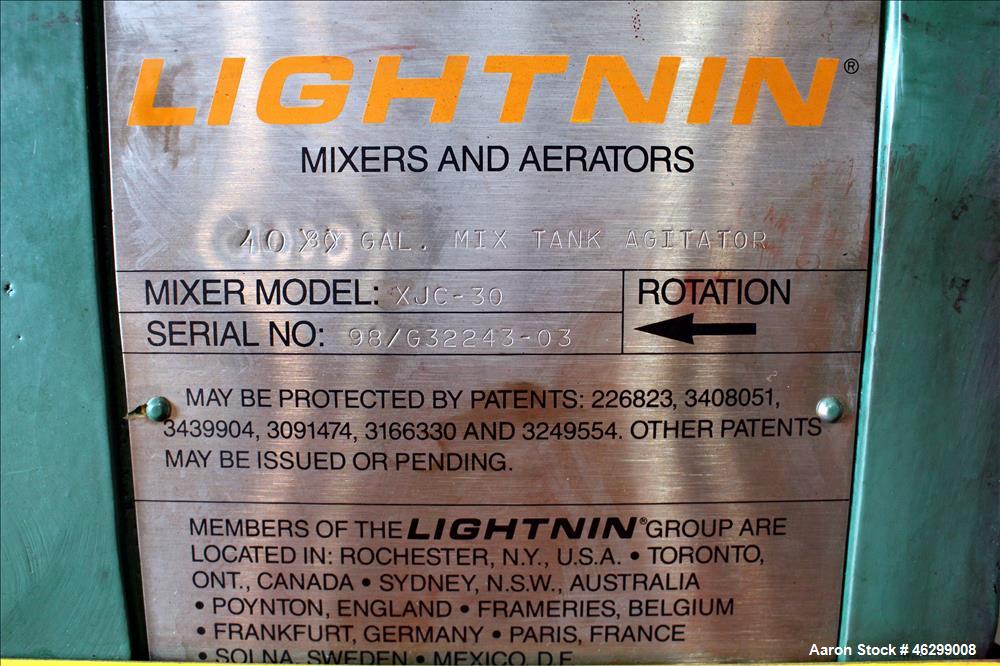 Used Tank, Approximately 40 Gallons, 304 Stainless Steel, Vertical. 20" Diameter x 30" straight side. Bolt-on flat top with 1/4 hinged cover, dished bottom. Top entering Lightnin agitator model XJC-3...