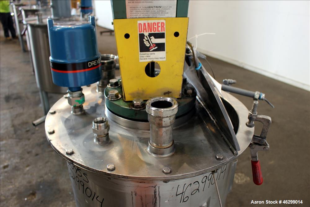 Used Tank, Approximately 40 Gallons, 304 Stainless Steel, Vertical. 20" Diameter x 30" straight side. Bolt-on flat top with 1/4 hinged cover, dished bottom. Top entering Lightnin agitator model XJC-3...