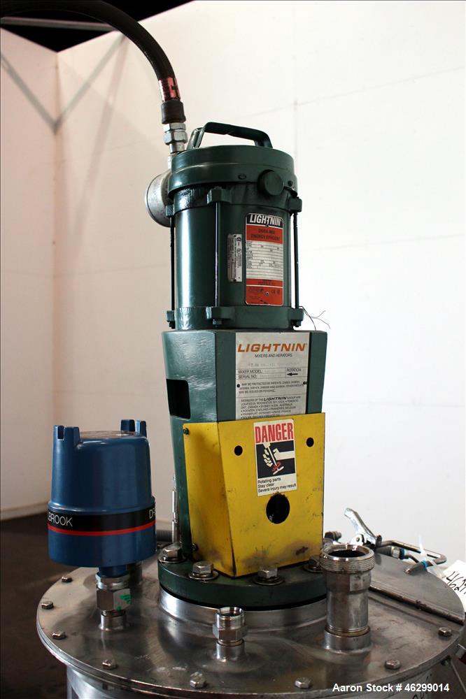 Used Tank, Approximately 40 Gallons, 304 Stainless Steel, Vertical. 20" Diameter x 30" straight side. Bolt-on flat top with 1/4 hinged cover, dished bottom. Top entering Lightnin agitator model XJC-3...