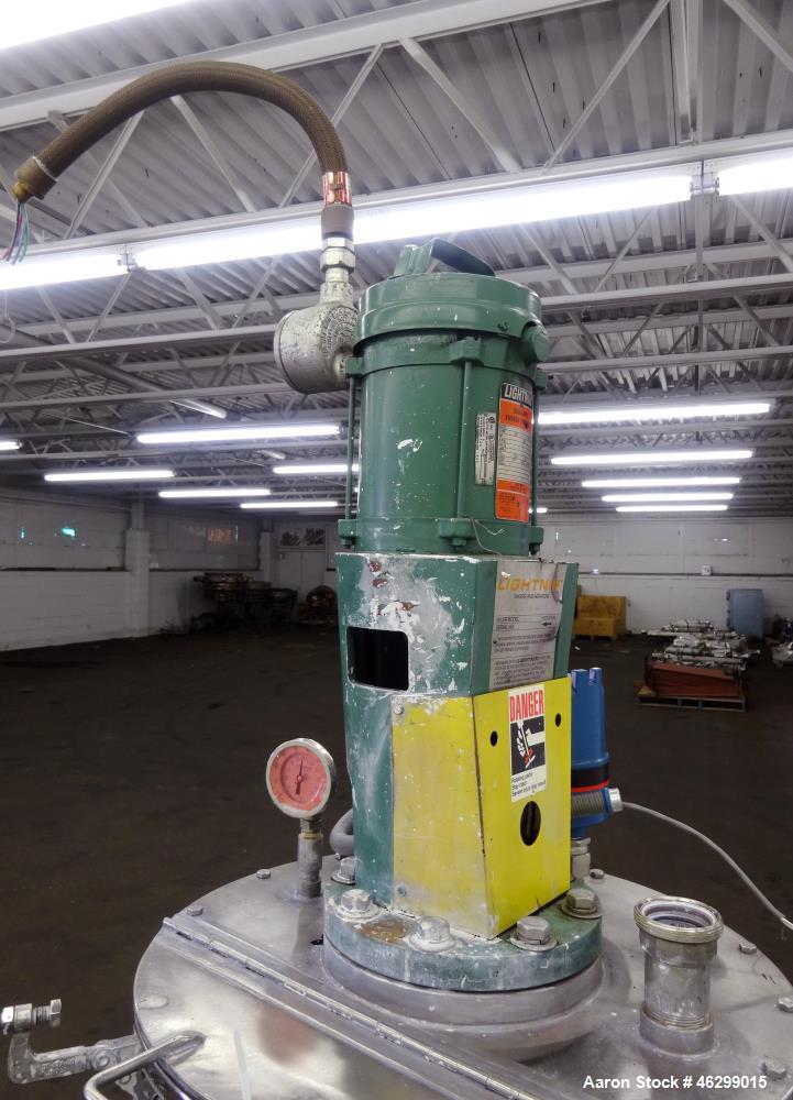 Used Tank, Approximately 40 Gallons, 304 Stainless Steel, Vertical. 20" Diameter x 30" straight side. Bolt-on flat top with 1/4 hinged cover, dished bottom. Top entering Lightnin agitator model XJC-3...