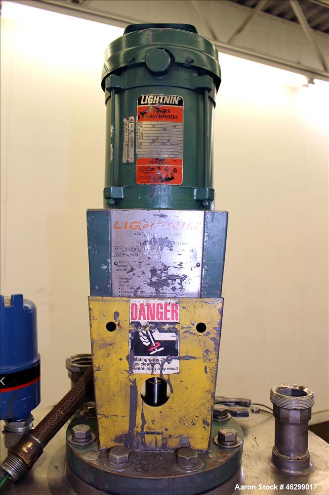 Used Tank, Approximately 40 Gallons, 304 Stainless Steel, Vertical. 20" Diameter x 30" straight side. Bolt-on flat top with 1/4 hinged cover, dished bottom. Top entering Lightnin agitator model XJC-3...