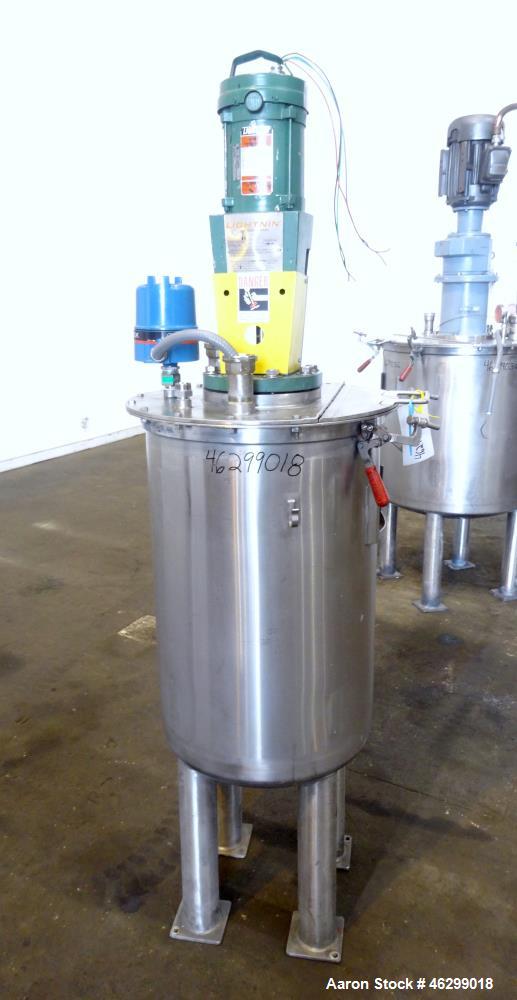 Used Tank, Approximately 40 Gallons, 304 Stainless Steel, Vertical. 20" Diameter x 30" straight side. Bolt-on flat top with 1/4 hinged cover, dished bottom. Top entering Lightnin agitator model XJC-3...