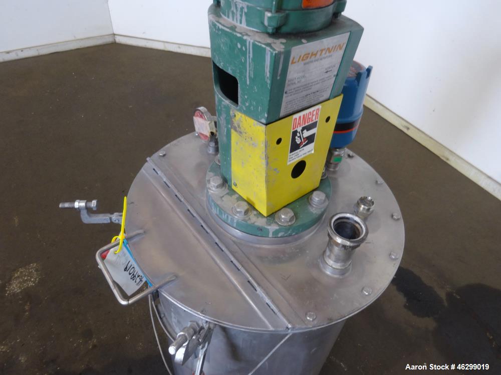 Used Tank, Approximately 40 Gallons, 304 Stainless Steel, Vertical. 20" Diameter x 30" straight side. Bolt-on flat top with 1/4 hinged cover, dished bottom. Top entering Lightnin agitator model XJC-3...