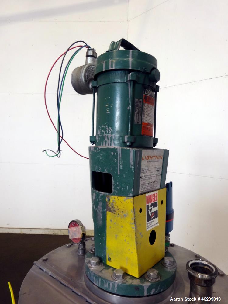 Used Tank, Approximately 40 Gallons, 304 Stainless Steel, Vertical. 20" Diameter x 30" straight side. Bolt-on flat top with 1/4 hinged cover, dished bottom. Top entering Lightnin agitator model XJC-3...