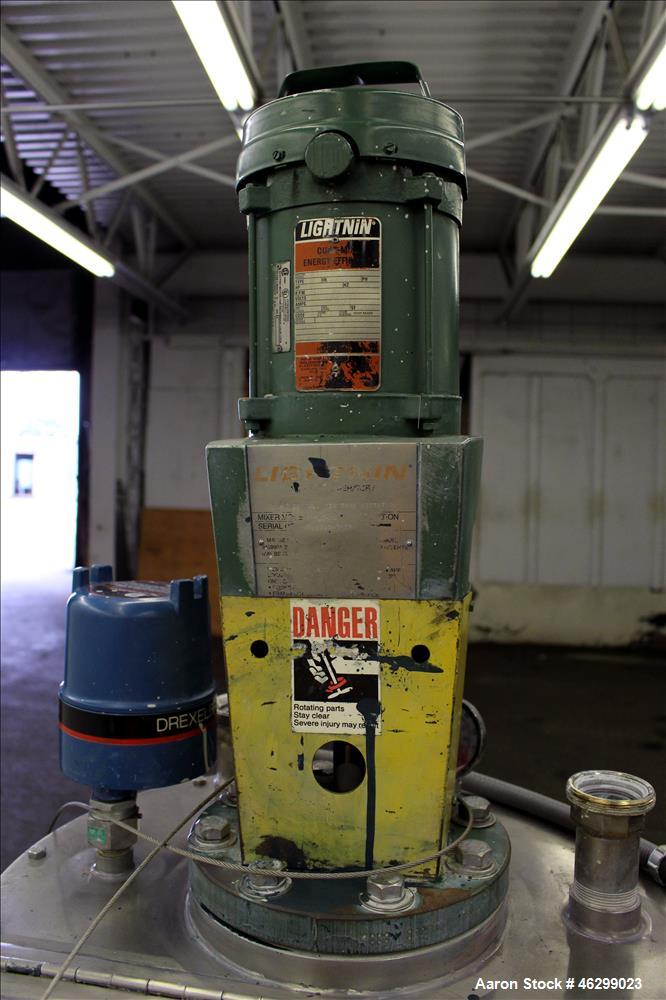 Used Tank, Approximately 40 Gallons, 304 Stainless Steel, Vertical. 20" Diameter x 30" straight side. Bolt-on flat top with 1/4 hinged cover, dished bottom. Top entering Lightnin agitator model XJC-3...