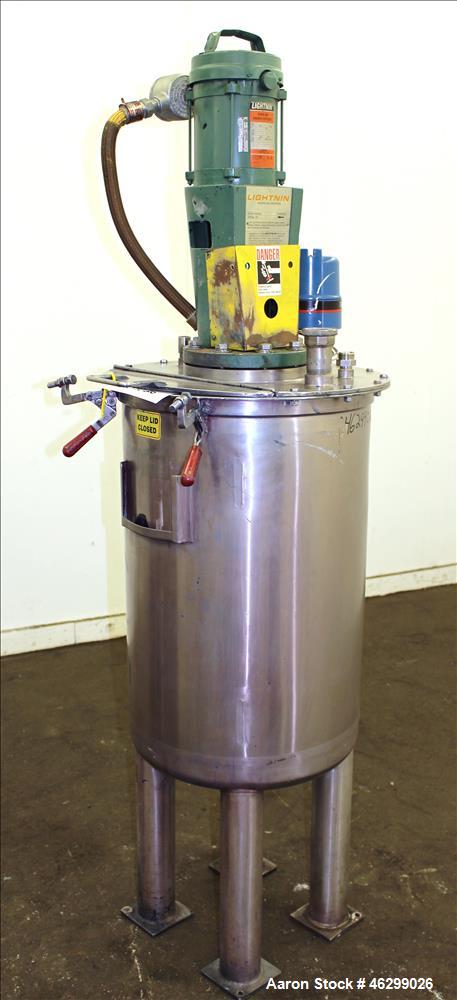 Used Tank, Approximately 40 Gallons, 304 Stainless Steel, Vertical. 20" Diameter x 30" straight side. Bolt-on flat top with 1/4 hinged cover, dished bottom. Top entering Lightnin agitator model XJC-3...