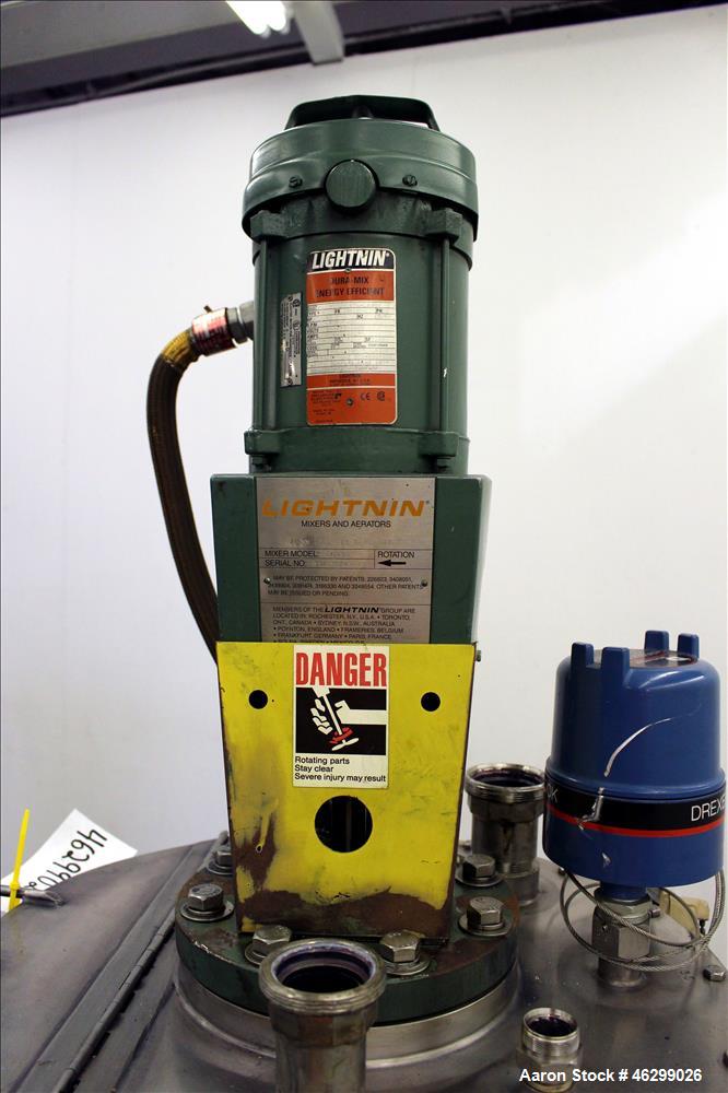 Used Tank, Approximately 40 Gallons, 304 Stainless Steel, Vertical. 20" Diameter x 30" straight side. Bolt-on flat top with 1/4 hinged cover, dished bottom. Top entering Lightnin agitator model XJC-3...