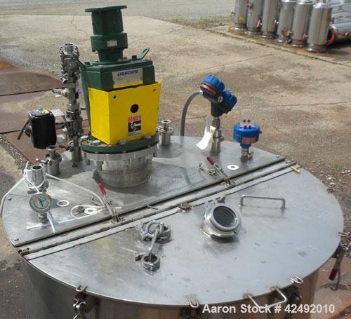 Used Tank, 440 Gallon, 304 Stainless Steel, Vertical. 48" Diameter x 52" straight side. Open top with a 2 piece cover, 1/2 bolt on, 1/2 clamp, dished bottom. Off center top entering Lightnin agitator...