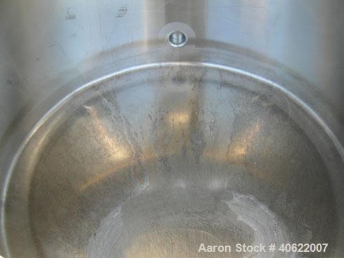 Used Tank, approximate 70 gallon, 316 stainless steel, vertical. Approximate 37" diameter x 15" straight side.  1 piece angled hinged top cover, sloped bottom. Openings: top (3) 2" triclamp, 6 1/2"; ...