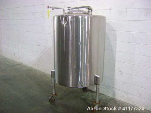 Used Perma-San Tank, 150 gallon, stainless steel, vertical. Closed top with manway, sloped bottom. Mounted on 3 legs with casters.